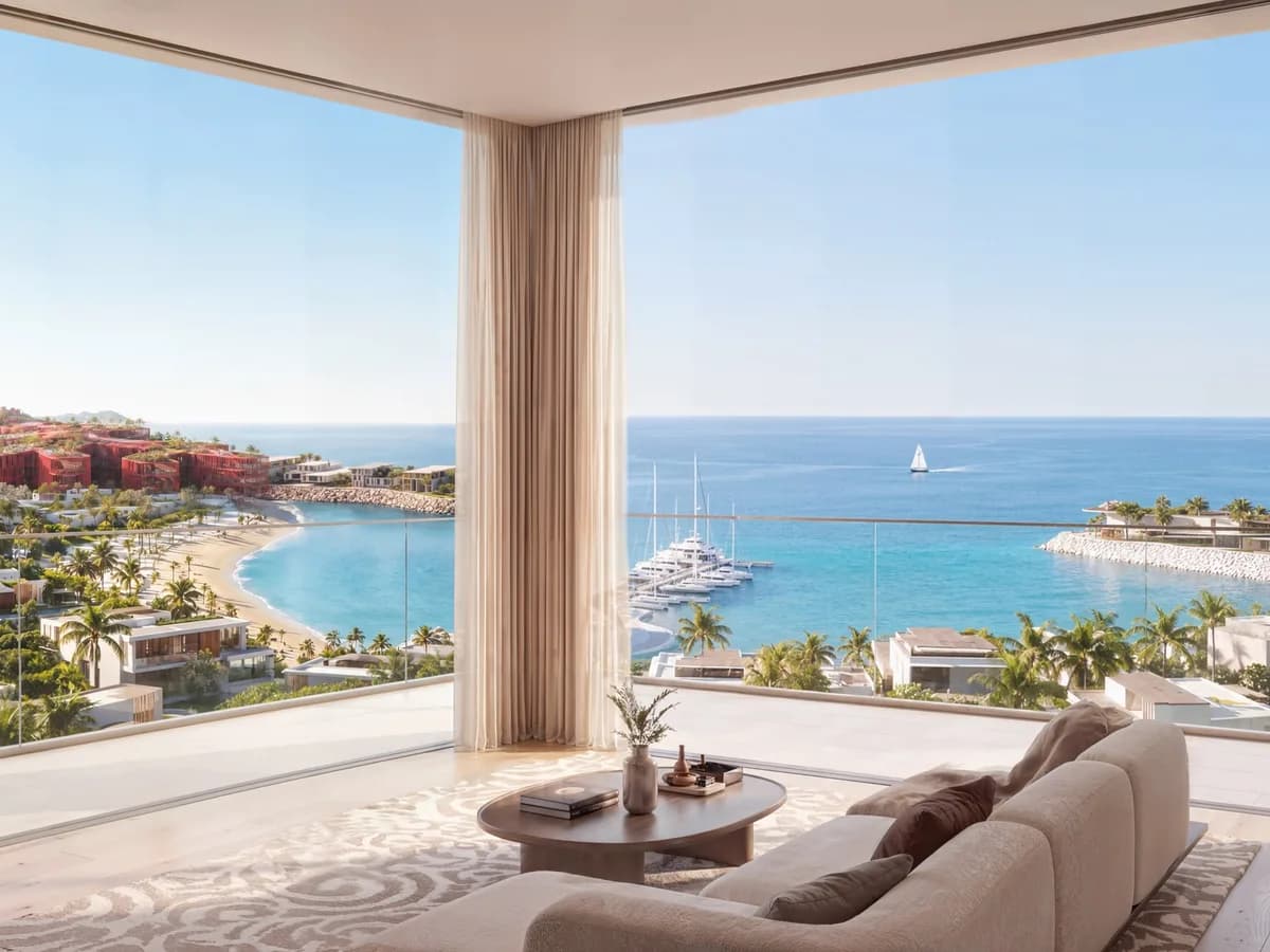 Render of a corner living room with a curved sofa and full-height glazing overlooking the beach, marina and sea