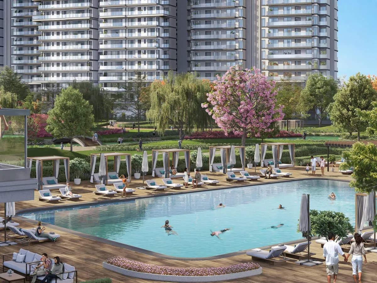 Artist's impression of a swimming pool with cabanas and sun loungers on a timber deck, with residential towers and gardens behind