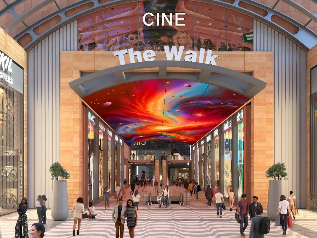 Render of the 'Cine – The Walk' arcade entrance with an LED ceiling, escalators and shops on both sides